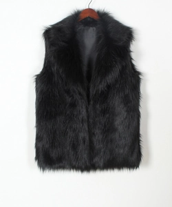 Detail view of black faux fur vest featuring wide lapel collar and smooth inner lining