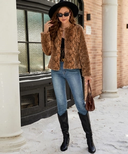 Detail shot of brown animal print faux fur jacket on model in urban street setting