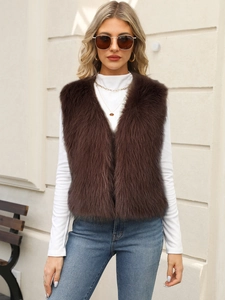 Detail of soft dark brown faux fur vest with V-neckline on model in outdoor setting
