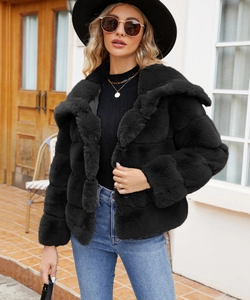 Detail view of the soft fluffy texture and wide collar of this black faux fur jacket