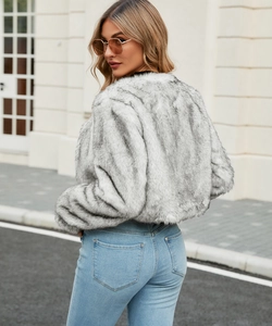 Rear view of a fluffy grey and white faux fur short jacket paired with light blue jeans