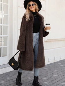 Women's dark brown faux fox fur long coat styled with jeans and boots for winter