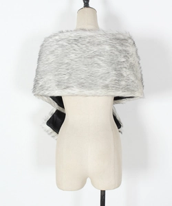 Detail of grey and white faux fur shawl with smooth black lining on a beige mannequin
