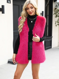 Detail of vibrant rose pink faux fur vest featuring a long shaggy texture and open front