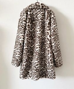 Detailed view of mid-length faux fur coat featuring a bold leopard print pattern