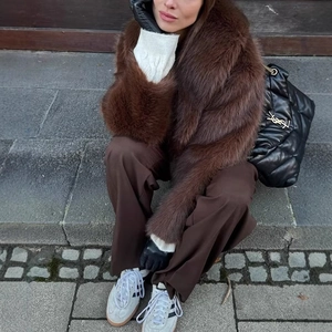 Detail of a brown faux fur coat styled for winter street fashion with chic gloves