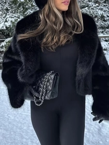 Detail of premium black faux fur jacket showing fluffy texture and wide lapels in snow