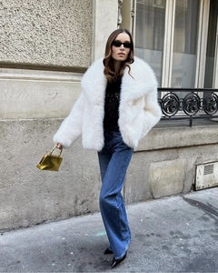 Détail d'un manteau blanc en fausse fourrure avec grand revers et texture douce