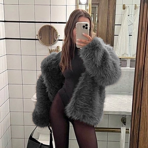 Detail of grey long-haired faux fur coat showing plush texture and urban stylish fit