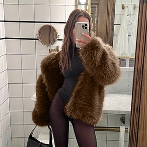 Close-up of fluffy leopard print faux fox fur texture and lapel collar of long coat