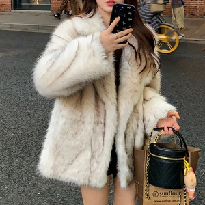 Close-up of cream faux fur coat featuring a large lapel and plush long-pile texture