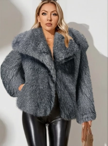 Détail d'un manteau en fausse fourrure gris foncé montrant une texture douce et luxueuse