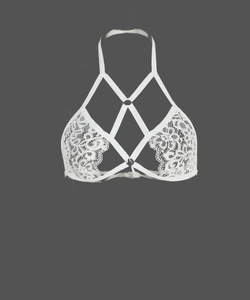 Détails d'un soutien-gorge cage en dentelle blanche avec motifs floraux et lanières