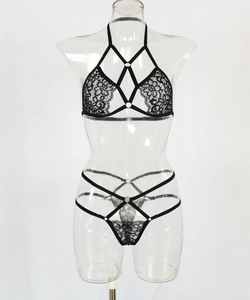Detailed close-up of a black lace halter bra featuring intricate strappy bandage design