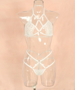Close-up of white lace halter neck bra with strappy details and intricate embroidery