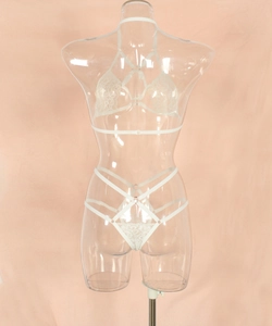 Detailed view of white lace halter bra and strappy body chain embroidery texture