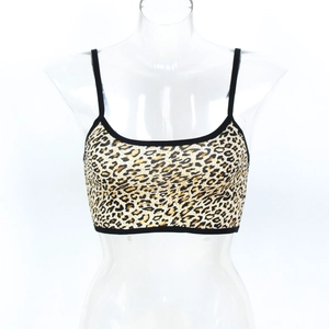 Détail d'un crop top léopard avec fines bretelles noires et bordures en forme de U
