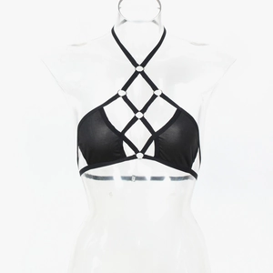 Détail d'un haut de bikini cage noir avec anneaux métalliques et brides croisées