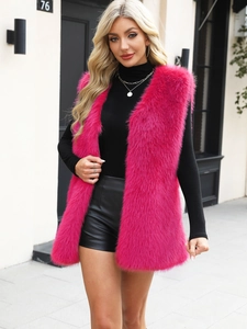 Street style view of a rose pink faux fur vest for women over a black turtleneck top