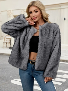 Dunkelgraue Damen Kunstpelzjacke kombiniert mit High-Waist-Jeans in einer urbanen Umgebung