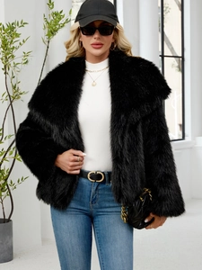 Detail shot of the plush black faux fur jacket texture and large collar on a model