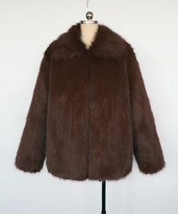 Detail of dark brown faux fur jacket showing the dense plush texture and lapel design