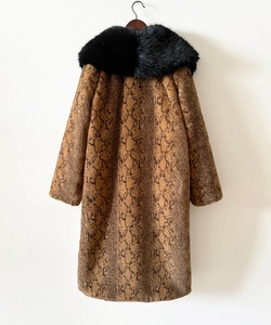 Détail d'un manteau en fausse fourrure avec motif serpent et grand col en fourrure noire