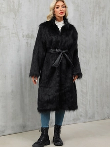 Detail of long black faux fur coat with leather waist belt and soft textured finish