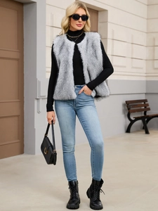 Outdoor street style view of a fluffy grey faux fur vest worn with black turtleneck and jeans