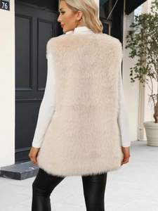 Outdoor street style view of a beige faux fur vest with soft plush texture and long cut
