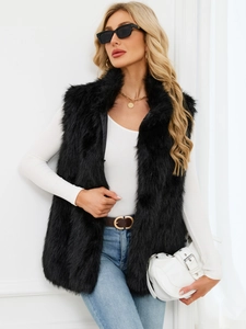 Elegant black faux fox fur vest with high collar paired with jeans for a chic winter look