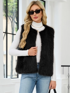 Detail shot of black faux fur vest paired with a white turtleneck and blue denim