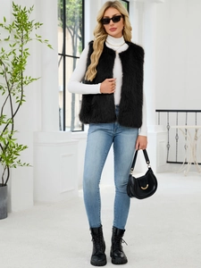 Fashionable black faux fur vest paired with white top and blue jeans in urban style