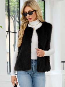 Detailed view of a black faux fur vest with a V-neck, worn over a white turtleneck top