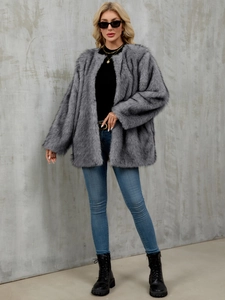 Detailed view of plush grey faux fur coat texture with open front design on model