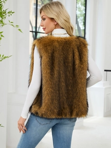 Back view of a long faux fur vest in tan with black tips over a white turtleneck