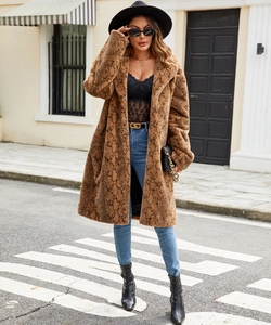 Detail of faux fur coat featuring brown snake print pattern and wide notch lapel