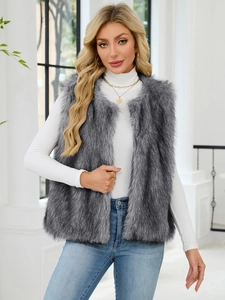Detail of grey faux fur vest layered over a white turtleneck and casual denim jeans