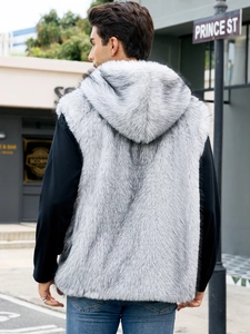 Outdoor street view of the hooded faux fur vest featuring long grey and white plush texture
