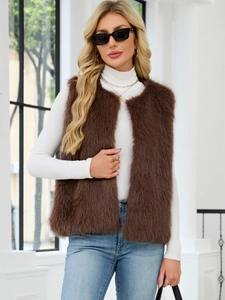 Detail of a plush brown faux fur vest styled with a white turtleneck and denim jeans