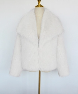 Detailed close-up of white faux fox fur coat with a large lapel and thick texture