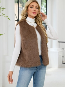 Close-up of the plush brown faux fur vest texture on a model in a bright indoor setting