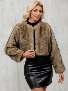 Détail de la texture fausse fourrure beige d'une veste courte sans col et jupe cuir