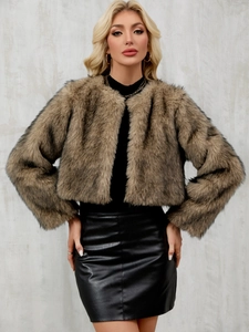 Détail d'une veste courte en fausse fourrure beige avec une texture douce et luxueuse