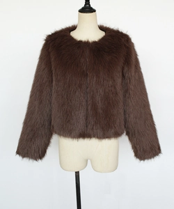 Texture détaillée de fourrure synthétique marron foncé sur une veste courte sans col