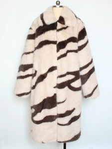 Detailed view of plush faux zebra fur texture on long coat with oversized lapel