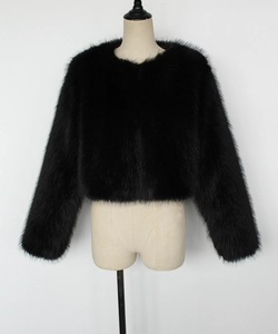 Détail d'une veste en fausse fourrure noire montrant la texture douce et le col rond