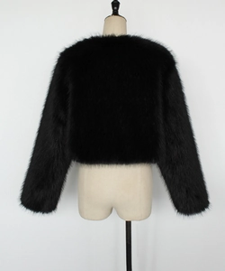Détail de la texture en fausse fourrure noire et du col rond sur une veste courte
