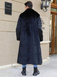 Macro shot of long black faux fur coat for men showing thick texture and glossy finish