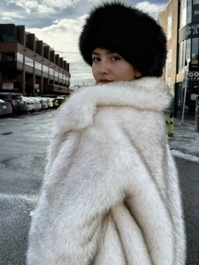 Winter outfit featuring a fluffy black faux fur hat and white plush faux fur coat for women
